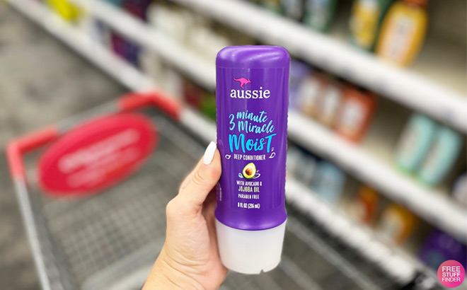 A Person Holding Aussie 3 Minute miracle in an Aisle at CVS