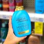 a hand holding ogx hair product